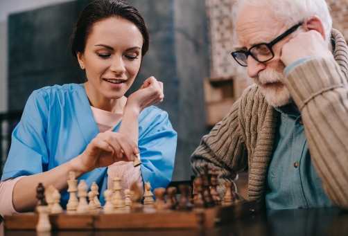 nurse and an older man are playing chess